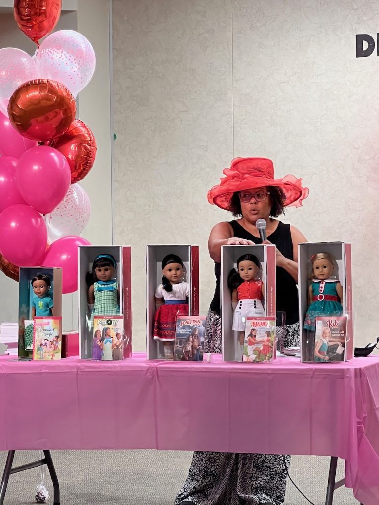 Photo Caption: Lynn Summers presented the University of California’s local Master Gardener/Master Food Preserver program, and served as MC. Here Summers describes the American Girl Dolls. Also introduced was Corrine Tan the 2022 Doll of the Year who is from Vietnam.