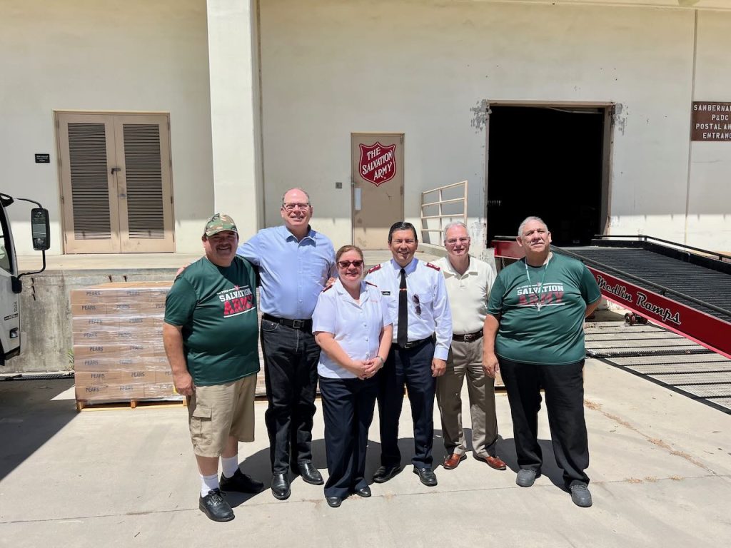 Left to right: Salvation Army officer, Sam Valdez, President Matthew Johnson of San Bernardino The Church of Jesus Christ of the Latter-day Saints. , Salvation Army Major Adelma Braga, Major Isais Braga,  Lonnie Gallaher, Stake Communication Director for the Church in San Bernardino, Salvation Army officer Mike Delgado.  In front of old donated by the church to serve the hungry in the san bernardino area.