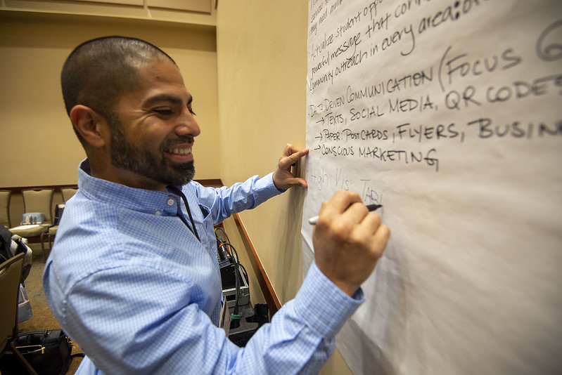 Participant writes notes on board in breakout room