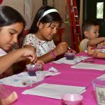 Boys and girls learned how to make their own preserves to top the scones that were served with tea. Left to right: Ariana Alvarada, Naiomy Zepeda and Emilin Zepeda. Photo by Chris Sloan