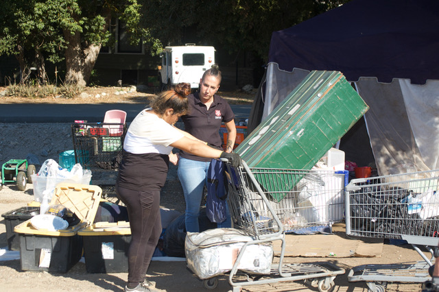 Photo Caption: Naomi Kuhlman talks with a homeless woman about her options for assistance. She and her spouse were camped out in Redlands Sylvan Park.